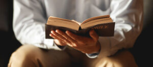 man holding and studying a bible