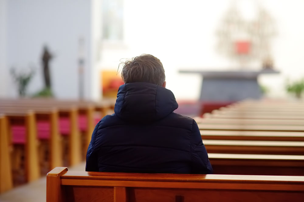 man sitting on church pews